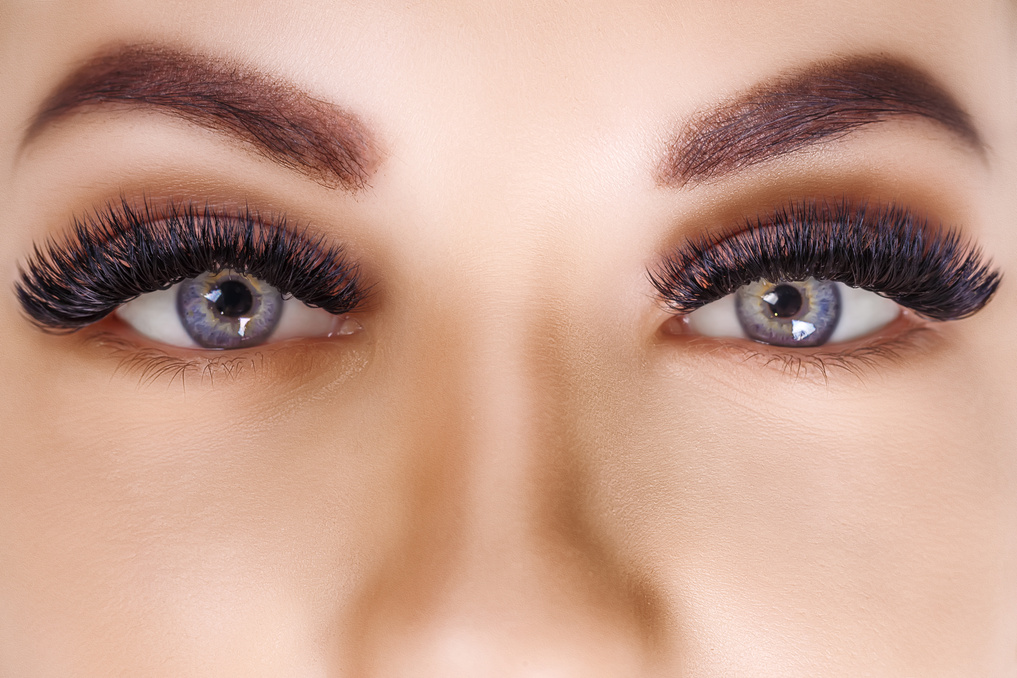 Eyelash Extension Procedure. Woman Eye with Long Eyelashes. Close up, selective focus. Fashion, russian volume
